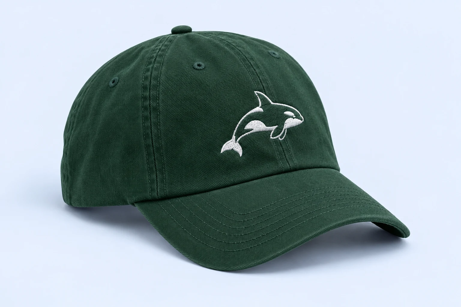 Forest-green cap with a white embroidered orca